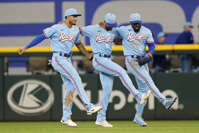 Texas Rangers out fielders Adolis Garcia, right, Leody Taveras, center, and Adolis Garcia dance together after the final out of a baseball game against the Seattle Mariners in Arlington, Texas, Sunday, August 14, 2022. The Rangers won 5-3. (Photo by L.M. OteroAP Photo)