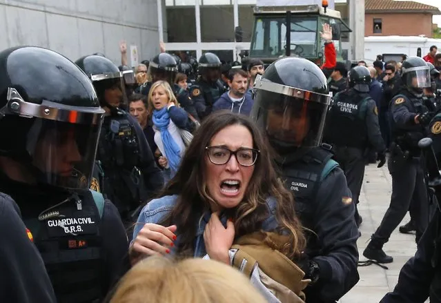 People clash with Spanish Guardia Civil guards outside a polling station in Sant Julia de Ramis, where Catalan president was supposed to vote, on October 1, 2017, on the day of a referendum on independence for Catalonia banned by Madrid. (Photo by Raymond Roig/AFP Photo)