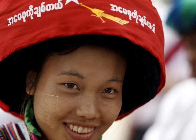 An ethnic Lisu woman with traditional headgear waits for Myanmar pro-democracy leader Aung San Suu Kyi to arrive to give a speech on voter education at the Hsiseng township in Shan state, Myanmar September 5, 2015. The words on the cloth read, “I love mother Suu”. (Photo by Soe Zeya Tun/Reuters)