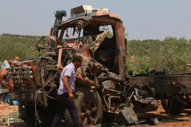 A man walks past a damaged truck after airstrikes on the outskirts of the rebel-held town of Atareb in Aleppo province, Syria August 4, 2016. (Photo by Ammar Abdullah/Reuters)
