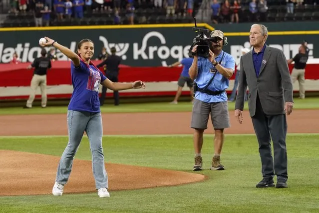 Former President George W. Bush, right, looks on as Andita Pollozani throws out the the first ceremonial pitch to recognize the 21st anniversary of Patriot Day before a baseball game between the Toronto Blue Jays and the Texas Rangers in Arlington, Texas, Sunday, September 11, 2022. (Photo by L.M. Otero/AP Photo)