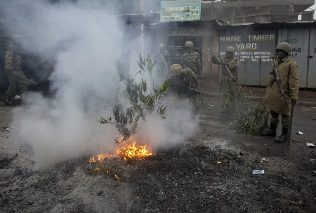 Police put down fires set alight by protesters in the Kibera slum in Nairobi, Kenya, Thursday, October 26, 2017. (Photo by Darko Bandic/AP Photo)