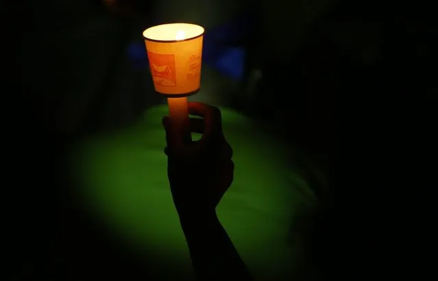 A picture made available on 16 August 2016 shows a Seongju-gun resident during a candlelight vigil after some 908 residents shaved their heads during a rally against the government's decision to deploy the US THAAD defense system in Seongju-gun, Gyeongsangbuk-do Province, some 300km south of Seoul, South Korea, 15 August 2016. South Korea's government announced its the decision on 13 July, to allow the US to deploy the Terminal High Altitude Area Defense (THAAD) system in Seongju-gun to counter North Korea's missile threats. (Photo by Yang Ji-Woong/EPA)