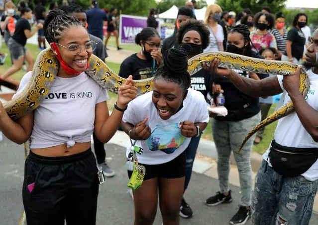 Women hold a python during events to mark Juneteenth, which commemorates the end of slavery in Texas, two years after the 1863 Emancipation Proclamation freed slaves elsewhere in the United States, amid nationwide protests against racial inequality, in Tulsa, Oklahoma, U.S., June 19, 2020. (Photo by Goran Tomasevic/Reuters)
