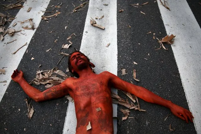 An activist covered in fake blood performs during a protest against the death of Semiao Vilhalva, a leader of the Guarani Kaiowa tribe, in Sao Paulo September 17, 2015. (Photo by Nacho Doce/Reuters)