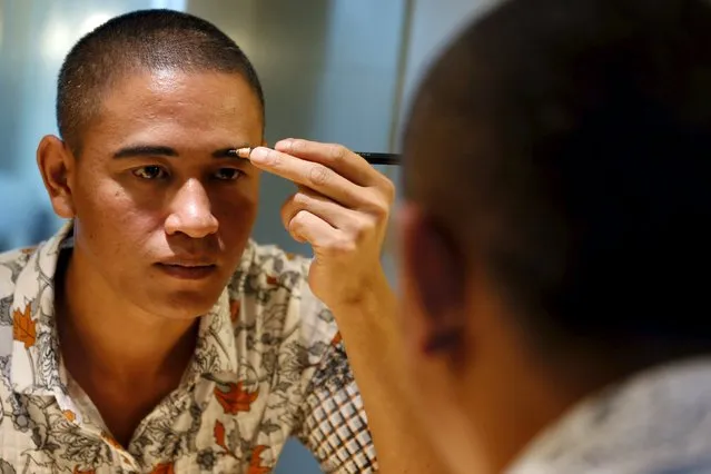 Xiao Jiguo, a 29-year-old actor from China's Sichuan province, shapes his eyebrows as he gets ready to impersonate U.S. President Barack Obama in a hotel room in the southern Chinese city of Guangzhou September 17, 2015. (Photo by Bobby Yip/Reuters)
