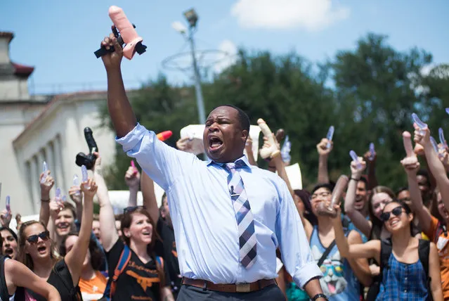 Daily Show correspondent Roy Wood Jr, holding a fake dildo gun in the air, joins students at a “Cocks Not Glocks” gun protest in Austin at the University of Texas, US on August 24, 2016. (Photo by ZUMA Wire/REX Shutterstock)