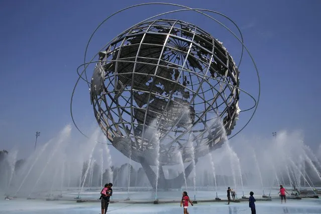 People cool off in the water at the Unisphere at Flushing Meadows Corona Park in the Queens borough of New York August 18, 2015. (Photo by Shannon Stapleton/Reuters)