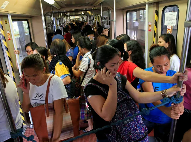 Commuters stand inside a jam-packed passenger coach of the Light Rail Transit System (LRT) at the central station in Metro Manila, Philippines June 21, 2016. (Photo by Romeo Ranoco/Reuters)