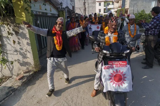 Rajan Bhattarai, leader of Communist Party of Nepal (Unified Marxist–Leninist), dances with his supporters as he participates in an election campaign ahead of the general election in Kathmandu, Nepal, Monday, November 14, 2022. (Photo by Niranjan Shrestha/AP Photo)