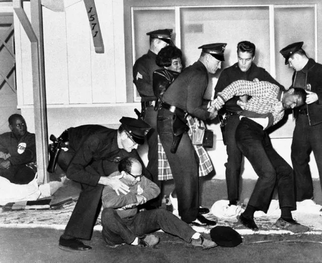 A group of “dwell ins” are evicted from a housing project in suburban Los Angeles by the police, December 12, 1962. The group, sponsored by the Congress of Racial Equality, camp out on the door step of a house in projects obviously denying access to blacks. They hope that the resulting publicity will bring about a favorable public reaction. (Photo by AP Photo)