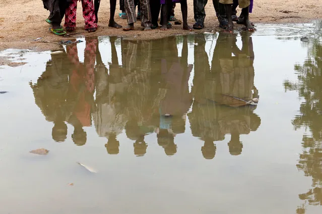 Boys are reflected in water at the internally displaced people's camp in Bama, Borno State Nigeria August 31, 2016. (Photo by Afolabi Sotunde/Reuters)