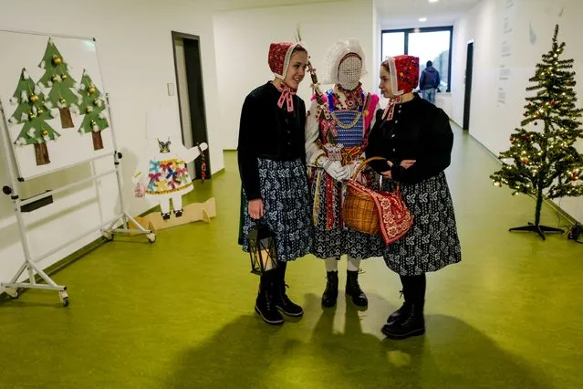 A Sorbian girl dressed as the traditional “Christ Child” (C), accompanied by two girls wearing traditional costumes, at a local school in Schleife, near Cottbus, Germany, 06 December 2022. As part of the old Sorbian traditional Christmas festival, a local girl dressed as the symbolic figure of the “Christ Child”, also known as the Bescherkind, goes house to house in her village to deliver sweets and bless the locals. The Western Slavic people of the Sorbs are acknowledged as a national minority with their own language in eastern Germany. (Photo by Filip Singer/EPA/EFE/Rex Features/Shutterstock)