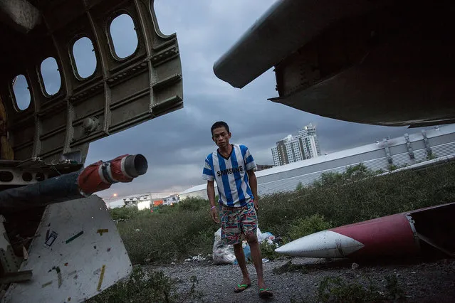 A Thai man walks toward his home in an airplane section after finishing a cigarette on September 12, 2015 in Bangkok, Thailand. (Photo by Taylor Weidman/Getty Images)