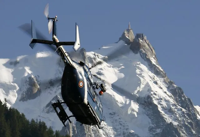 A French Gendarmerie rescue helicopter passes in front of the Aiguille du Midi as it takes off near Chamonix during search and rescue operations August 24, 2008. (Photo by Christian Hartmann/Reuters)