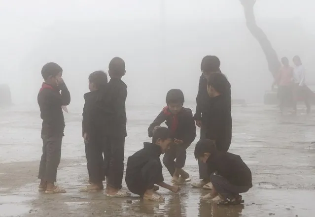 Hmong children play during a class break on a foggy day at Van Chai school in Dong Van district of Vietnam's northern province of Ha Giang, located on the border with China, September 21, 2015. (Photo by Reuters/Kham)