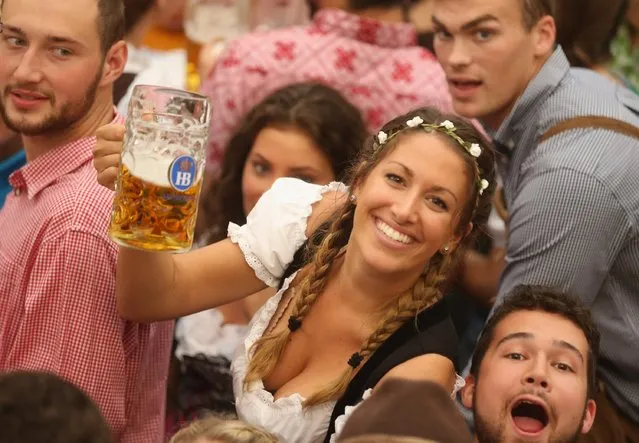 Visitors hold up one-litre glasses of beer to kick off the 2016 Oktoberfest beer festival in the Hofbraeu tent at Theresienwiese on September 17, 2016 in Munich, Germany. The 2016 Oktoberfest is taking place under heightened security due to fears over international terrorism. The fest will be open to the public through October 3. (Photo by Johannes Simon/Getty Images)