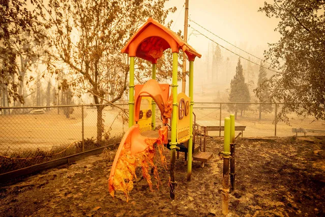 A melted slide smolders as a playground continues to burn at Pine Ridge school during the Creek fire in an unincorporated area of Fresno County, California on September 08, 2020. Wildfires in California have torched a record more than two million acres, the state fire department said on September 7, as smoke hampered efforts to airlift dozens of people trapped by an uncontrolled blaze. (Photo by Josh Edelson/AFP Photo)