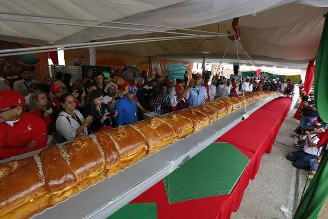 Workers weigh a giant ham bread, a typical Venezuelan Christmas dish, during an attempt to break the Guinness World Record for the biggest ham bread, in Caracas November 15, 2014. (Photo by Carlos Garcia Rawlins/Reuters)