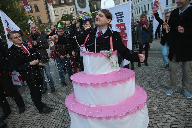 Satirical counter-demonstrators, including one dressed as Adolf Hitler and wearing a cake, pretend to celebrate the first anniversary since the first Pegida march nearby to where actual Pegida supporters were gathering on October 19, 2015 in Dresden, Germany. (Photo by Sean Gallup/Getty Images)