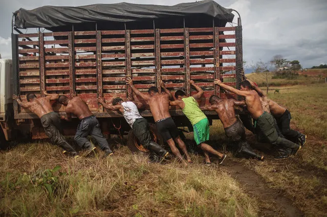 Revolutionary Armed Forces of Colombia (FARC) rebels and supporters help push a vehicle stuck in mud at their camp following the 10th Guerrilla Conference in the remote Yari plains where the peace accord was ratified by the FARC on September 25, 2016 in El Diamante, Colombia. The peace agreement attempts to end the 52-year-old guerrilla war between the FARC and the state, the longest-running armed conflict in the Americas which has left 220,000 dead. The final agreement is set to be signed on September 26 and will then be put to vote by the public in a referendum on October 2. The plan calls for a disarmament and re-integration of most of the estimated 7,000 FARC fighters. (Photo by Mario Tama/Getty Images)