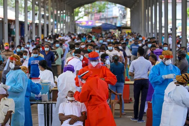 Sri Lankan health officials wearing PPE (Personal Protective Equipment) take swab samples from Sri Lankans to be tested for for COVID-19 virus at Colombo, Sri Lanka, on October 23, 2020. (Photo by Tharaka Basnayaka/NurPhoto via Getty Images)
