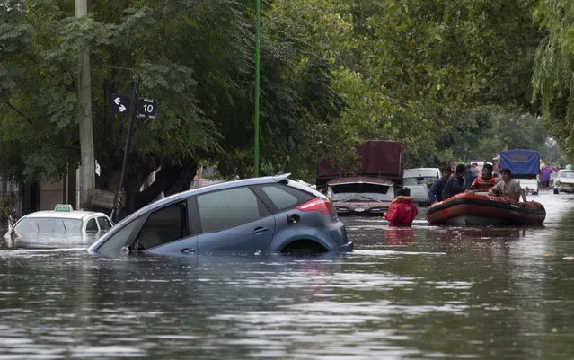 Rescue workers in a raft maneuver through a flooded street where cars are submerged along a street in La Plata, in Argentina's Buenos Aires province, Wednesday, April 3, 2013. At least 35 people were killed by flooding overnight in Argentina's Buenos Aires province, the governor said Wednesday, bringing the overall death toll from days of torrential rains to at least 41 and leaving large stretches of the provincial capital under water. (Photo by Natacha Pisarenko/AP Photo)