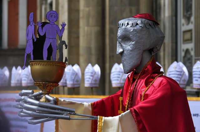 A sculpture representing a Catholic priest and a chalice filled with cutouts of children stands alongside bishop mitres with messages regarding pedophile priests, during a protest organized by the Mujeres Creando feminist association who are demanding the convictions of the priests accused of sexually abusing minors, outside the Metropolitan Cathedral in La Paz, Bolivia, May 16, 2024. (Photo by Juan Karita/AP Photo)
