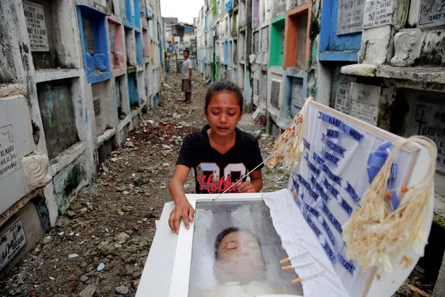 Kasandra Kate, 12, cries over the open coffin of her father Verigilio Mirano during his funeral at Navotas Public Cemetery in Manila, Philippines October 14, 2016. According to a family member, Mirano, who was using drugs but stopped after Rodrigo Duterte became the president, was killed by masked gunmen at his home on September 27th. (Photo by Damir Sagolj/Reuters)