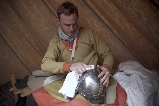 A re-enactor polishes his armour before a re-enactment of the Battle of Hastings, commemorating the 950th anniversary of the battle, in Battle, Britain October 15, 2016. (Photo by Neil Hall/Reuters)