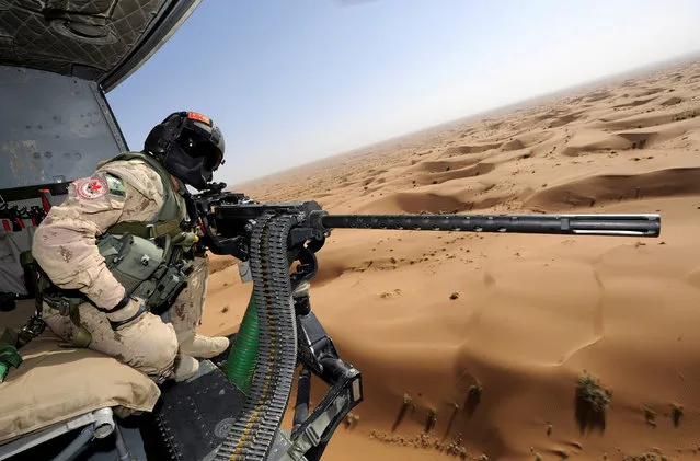 Canadian Forces door gunner Sergeant Chad Zopf leans out of a CH-146 Griffon helicopter during a training exercise in Kandahar district, Afghanistan June 18, 2011 in this handout photo obtained by Reuters March 19, 2018. (Photo by Sgt Matthew McGregor/Reuters/Canada Department of National Defence)