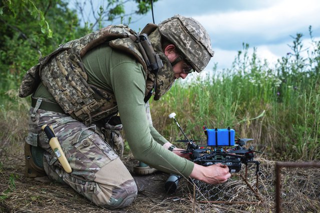 A service member of the 429th Achilles Separate Unmanned Aerial Systems Regiment prepares an FPV-drone for a fly at a position near the front line town of Kupiansk in Kharkiv region, Ukraine on June 23, 2025. (Photo by Viacheslav Ratynskyi/Reuters)
