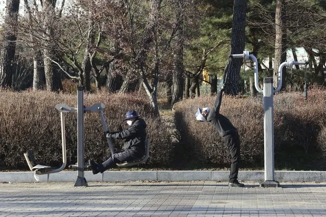 People wearing face masks as a precaution against the coronavirus exercise at a park at a park in Goyang, South Korea, Friday, December 4, 2020. The Korea Disease Control and Prevention Agency said Friday that 600 of the newly confirmed patients were domestically transmitted cases – nearly 80% of them in the densely populous Seoul area, which has been at the center of a recent viral resurgence. (Photo by Ahn Young-joon/AP Photo)