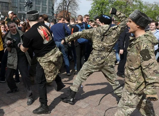 Fighters of National Liberation movement clash with protesters during clashes at a demonstration against President Vladimir Putin in Pushkin Square in Moscow, Russia, Saturday, May 5, 2018. Russians angered by the impending inauguration of Vladimir Putin to a new term as the country's president demonstrated throughout the country on Saturday. Police arrested hundreds, including protest organizer Alexei Navalny, the anti-corruption campaigner who is Putin's most prominent foe. (Photo by AP Photo/Stringer)