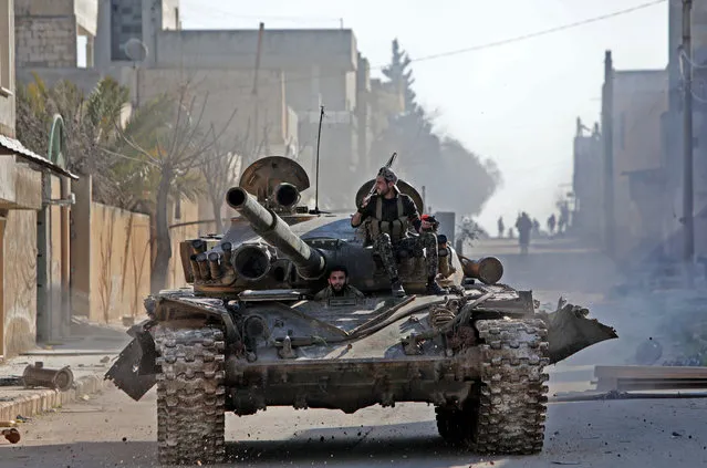 Turkey-backed Syrian fighters ride a tank in the town of Saraqib in the eastern part of the Idlib province in northwestern Syria, on February 27, 2020. Syrian rebels reentered the key northwestern crossroads town of Saraqib lost to government forces earlier this month but fierce fighting raged on in its outskirts today, an AFP correspondent reported. (Photo by Bakr Alkasem/AFP Photo)