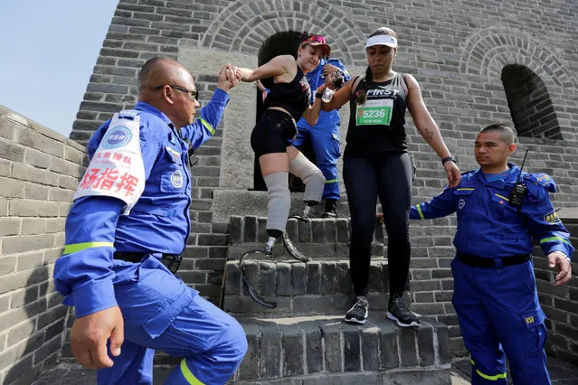 Rescuers help Portuguese runner Adriele Silva through a tower during the Great Wall Marathon at the Huangyaguan section of the Great Wall of China, in Jixian of Tianjin, China May 19, 2018. (Photo by Jason Lee/Reuters)