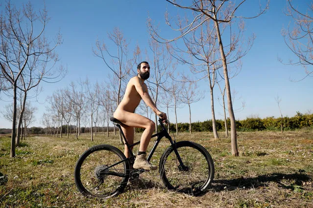 Alejandro Colomar poses naked on a bicycle in his vegetable garden, as Spanish court has ruled in favour of allowing him to continue walking around his village naked, as he has been doing since 2020, in Aldaia, near Valencia, Spain on February 3, 2023. (Photo by Eva Manez/Reuters)