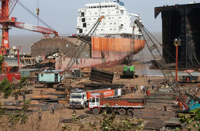 Workers sort out metal scrap of a decommissioned ship at the Alang shipyard in Gujarat, India, May 29, 2018. (Photo by Amit Dave/Reuters)