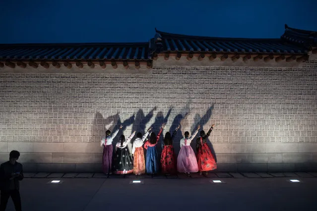 People wearing traditional Korean hanbok dress pose for photos as they visit Gyeongbokgung palace in central Seoul on November 4, 2016. (Photo by Ed Jones/AFP Photo)