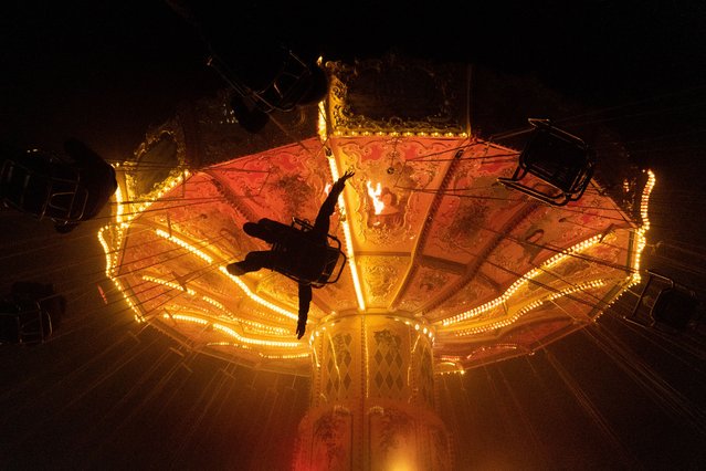 Visitors ride a swing attraction during the Hochheim Market in Hochheim, Germany on November 11, 2025. The traditional autumn fair has been held for more than 500 years. (Photo by Matias Basualdo/ZUMA Press Wire/Rex Features/Shutterstock)