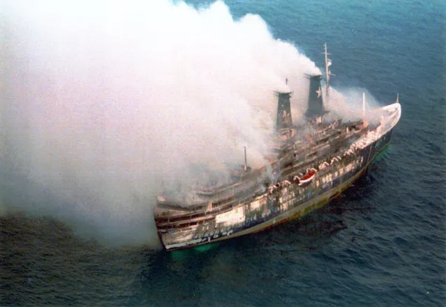 The Italian cruise ship Achille Lauro smokes in the Indian Ocean, some 160 miles off the Somali coast, Thursday, December 01, 1994. The Achille Lauro caught fire, Wednesday, and nearly 1,000 people aboard escaped on lifeboats to be rescued by passing ships. Two people are known to be dead one person is missing. (Photo by Ricardo Mazalan/AP Photo)