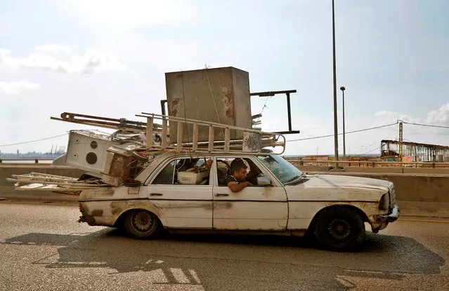 A man drives a car loaded with electronic and household appliances the Dbayeh highway, at the northern entrance of Lebanon's capital Beirut, on August 11, 2020, following a huge chemical explosion that devastated large parts of the city. (Photo by Joseph Eid/AFP Photo)