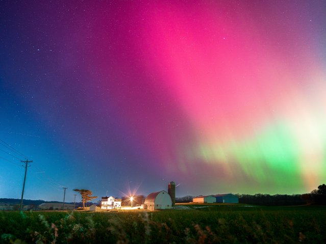 The Aurora Borealis lights up the night sky over Monroe, Wisconsin, on November 11, 2025, during one of the strongest solar storms in decades. The geomagnetic event pushes the northern lights deep into the continental United States, with vibrant pink, red, and green hues illuminating rural farmsteads and open fields across the Midwest. (Photo by Ross Harried/NurPhoto/Rex Features/Shutterstock)