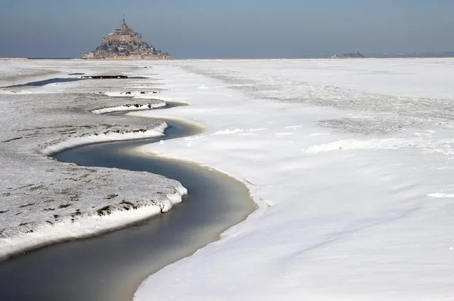 A view shows the snow-covered Bay of Mont Saint-Michel in the French western region of Normandy, as winter weather with snow and cold temperatures hits a large northern part of the country, France, February 10, 2021. (Photo by Stephane Mahe/Reuters)