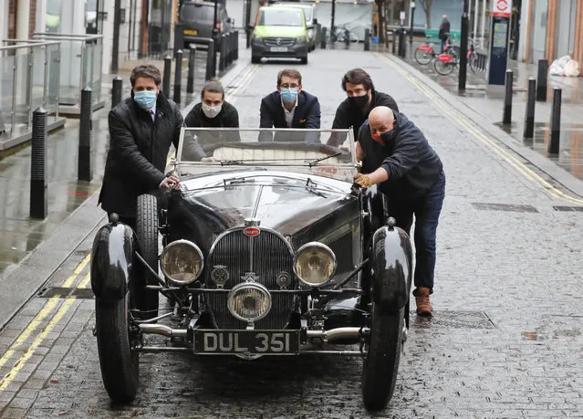 A 1937 Bugatti Type 57S, one of the world's most valuable and desirable pre-war motor cars, is pushed by staff outside the Bonhams auction house in London, Tuesday, February 16, 2021. Bonhams Legend of the Road Sale is featuring a 1937 Bugatti Type 57S, with an estimate £5,000,000 – 7,000,000. The Bugatti has been hidden for the past 50 years and is one of 42 examples of the 57S variants that were produced. (Photo by Frank Augstein/AP Photo)