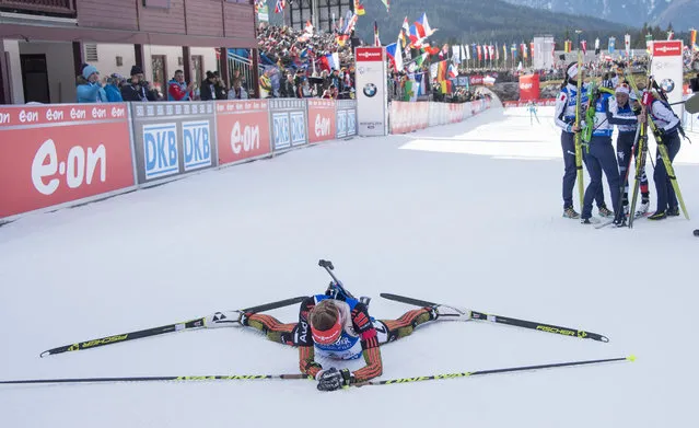Athletes of the Italian team (R) celebrate their victory as Franziska Preuss of the second placed German team lays down in the finish area during the women's 4x6 km relay event during the IBU Biathlon World Cup in Hochfilzen, Austria, on December 13, 2015. (Photo by Joe Klamar/AFP Photo)