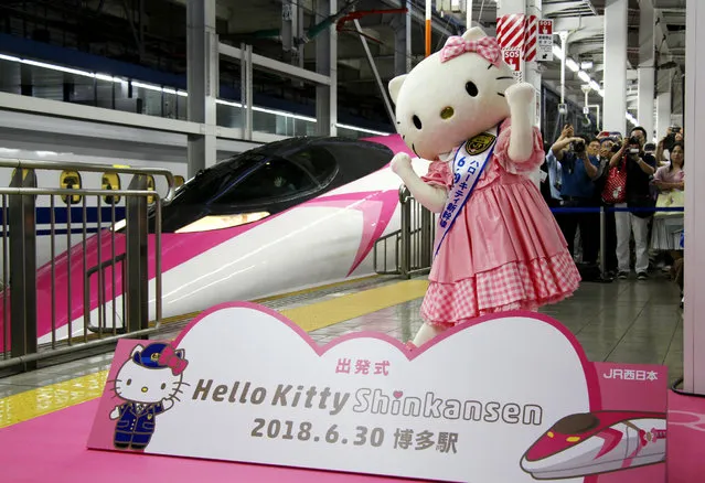 A Hello Kitty-themed “shinkansen” bullet train is unveiled at JR Shin Osaka station, in Osaka, western Japan, Saturday, June 30, 2018. The special shinkansen had its inaugural round trip Saturday between Osaka and Fukuoka, connecting Japan’s west and south until the end of September. The stylish train is painted pink and white, showcasing Hello Kitty images and trademark ribbons from flooring to seat covers and windows. (Photo by Kyodo News via AP Photo)
