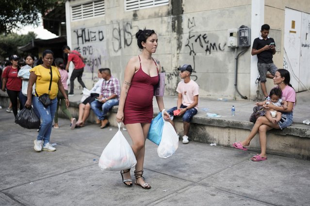 A pregnant woman carries the aid she received due to forced displacement caused by clashes between the rebels of the National Liberation Army (ELN) and dissidents of the former Revolutionary Armed Forces of Colombia (FARC), at the General Santander Stadium in Cucuta, Colombia, on January 23, 2025. (Photo by Nathalia Angarita/Reuters)