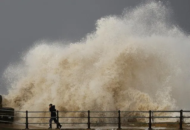 A woman is battered by a wave as he walks along the seafront in New Brighton, northern England November 16, 2016. (Photo by Phil Noble/Reuters)