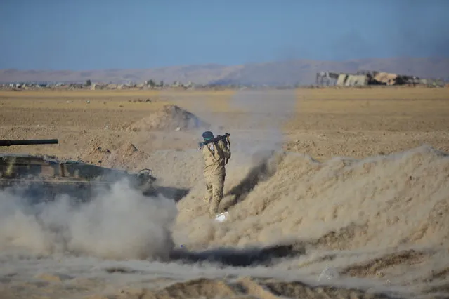 A member of Shi'ite fighters fires a RPG towards Islamic State militants during a battle with Islamic State militants on the outskirt of Tal Afar west of Mosul, Iraq, November 18, 2016. (Photo by Reuters/Stringer)